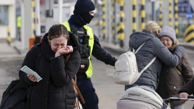 украинские беженцы и сотрудник польской полиции
