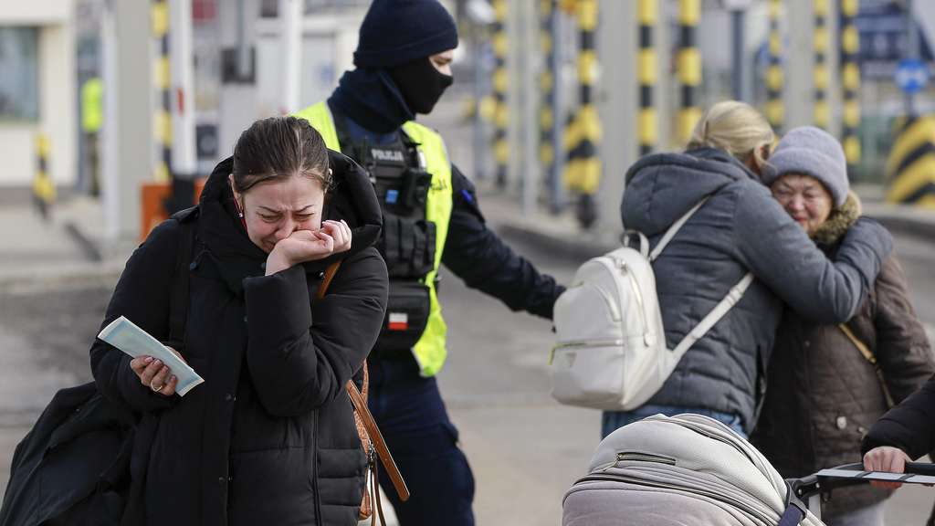 украинские беженцы и сотрудник полиции